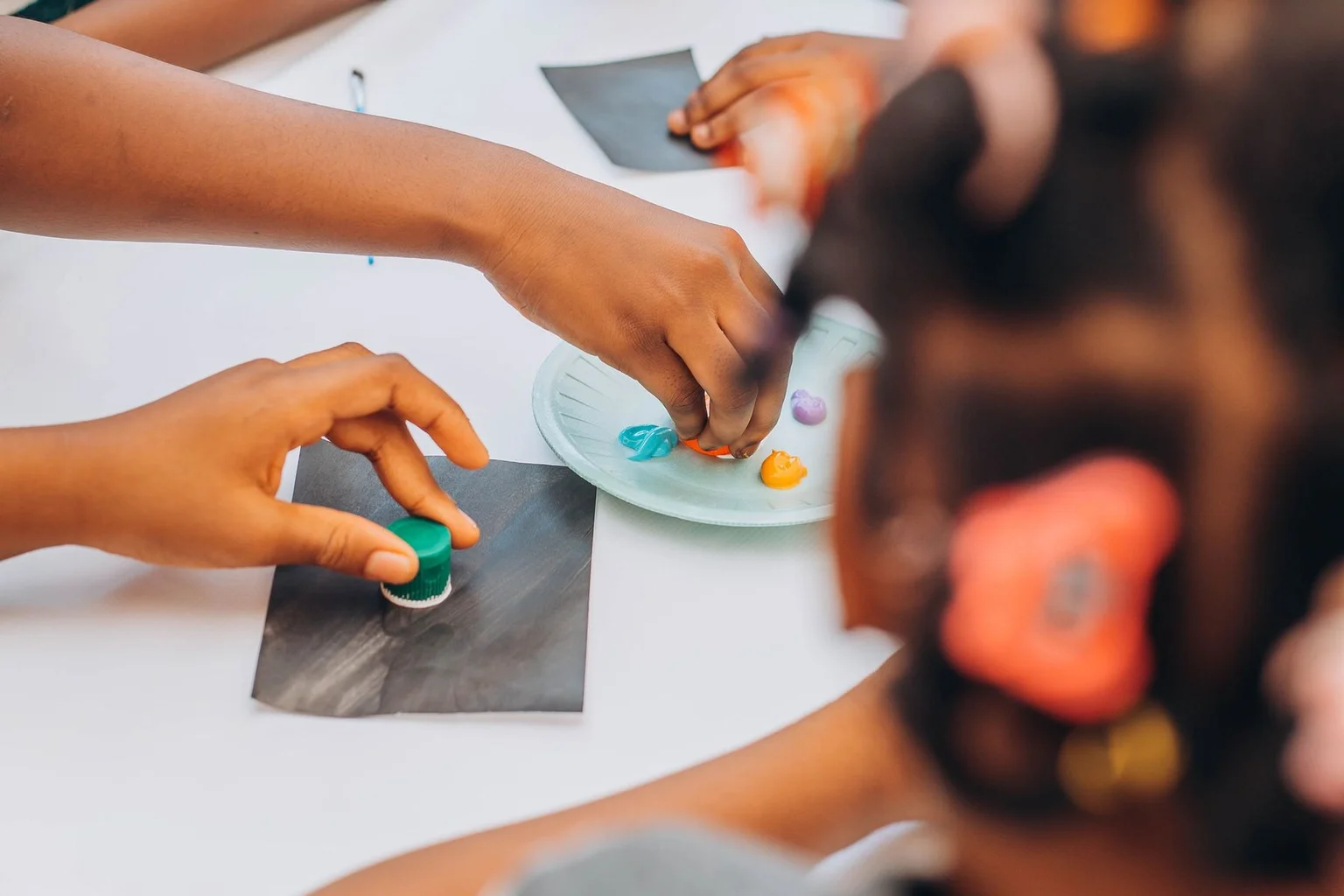 Children using colourful materials at a craft table